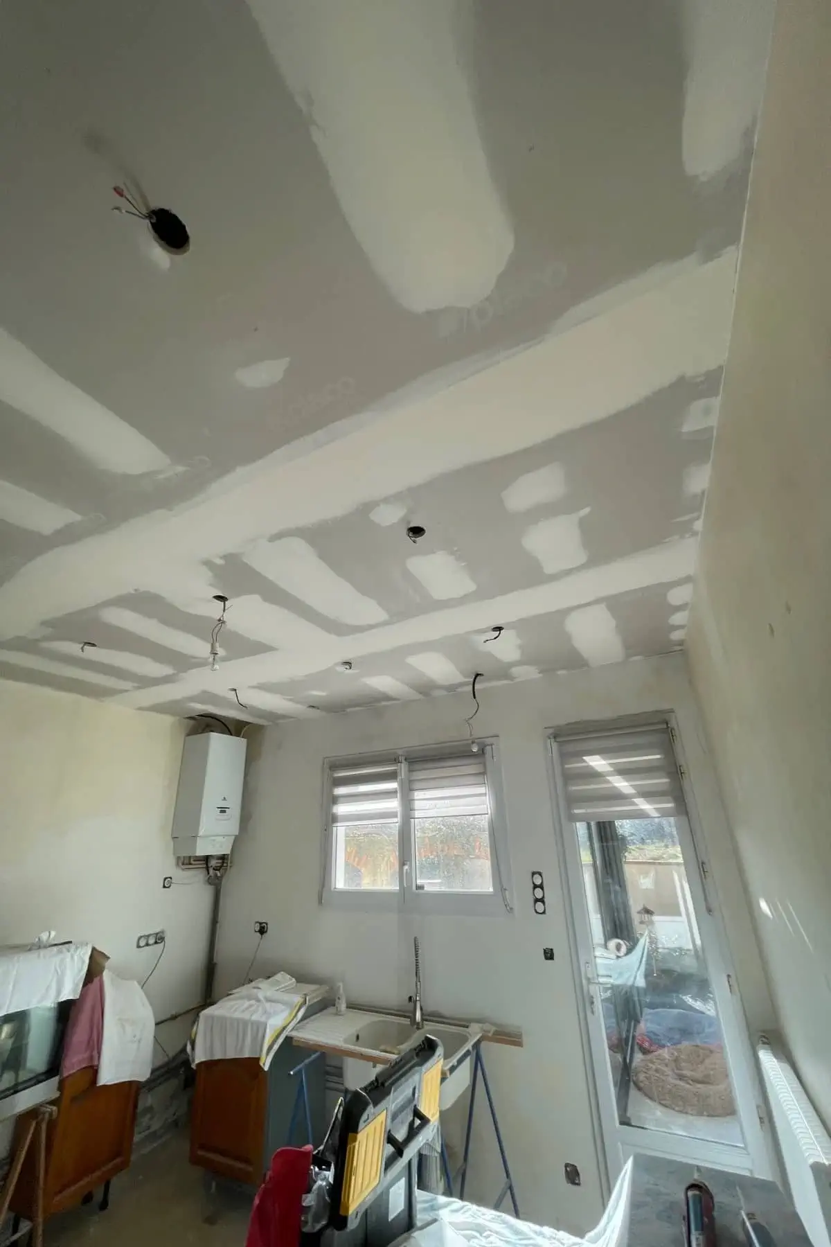 Artisan jointeur réalisant joint placo plafond cuisine